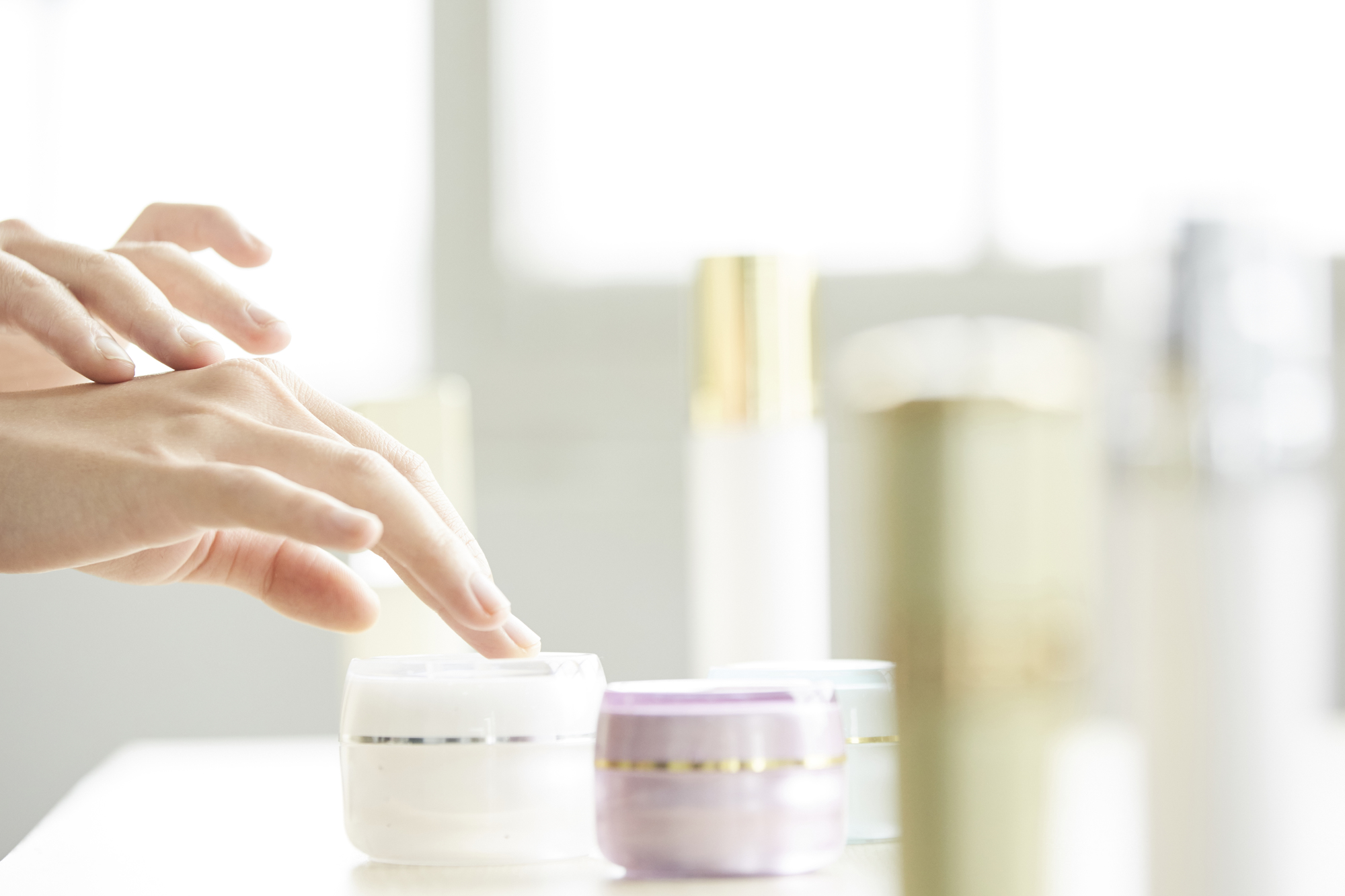紫外線ダメージに備える土台ケアとして保湿クリームを手に取る手元。セラミド補給や保湿で肌のバリア機能を整えるイメージ